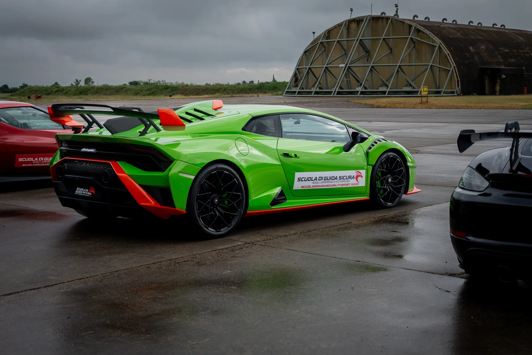 Lamborghini verde davanti agli hangar dell’aeroporto militare di Piacenza